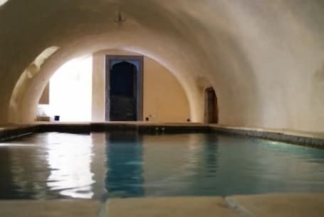 Una piscina techada, sillones reclinables de piscina