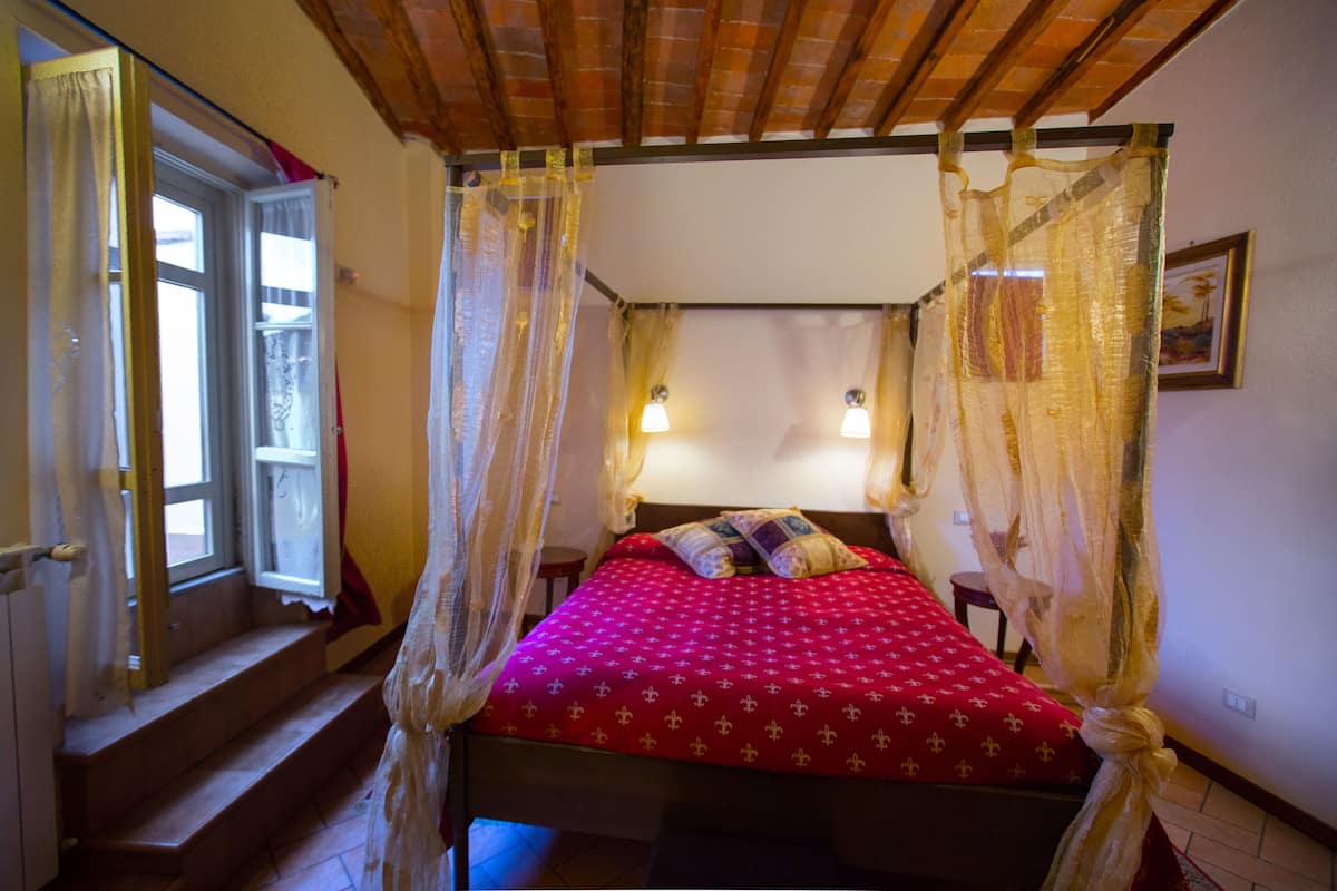 Un dormitorio con cama, ventana y escalera.