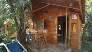 A wooden cabin with a porch, a dining table, and a blue chair. - Villaggio Verde (Sorrento)