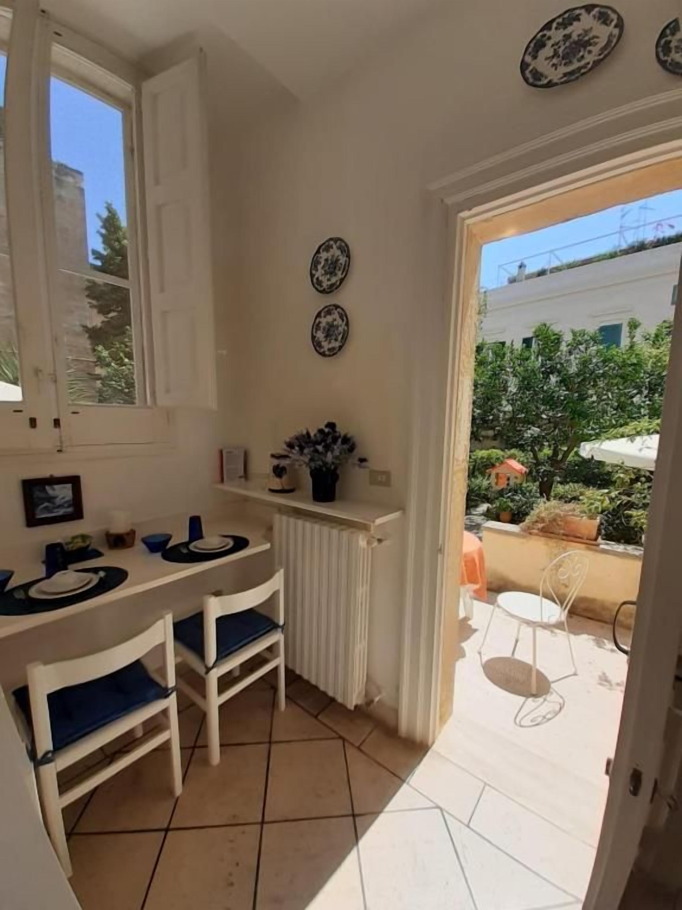A compact kitchen with a dining area, a radiator, and a view of the outside.