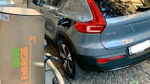 A gray SUV parked at an electric charging station with a building in the background. - Pension Liechtenstein (Vienna)