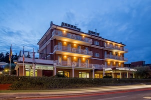 Egy többemeletes szálloda, amelynek erkélyei vannak, egy „AG. Immobilier” feliratú tábla, és egy „Marion Park Hotel” feliratú tábla.