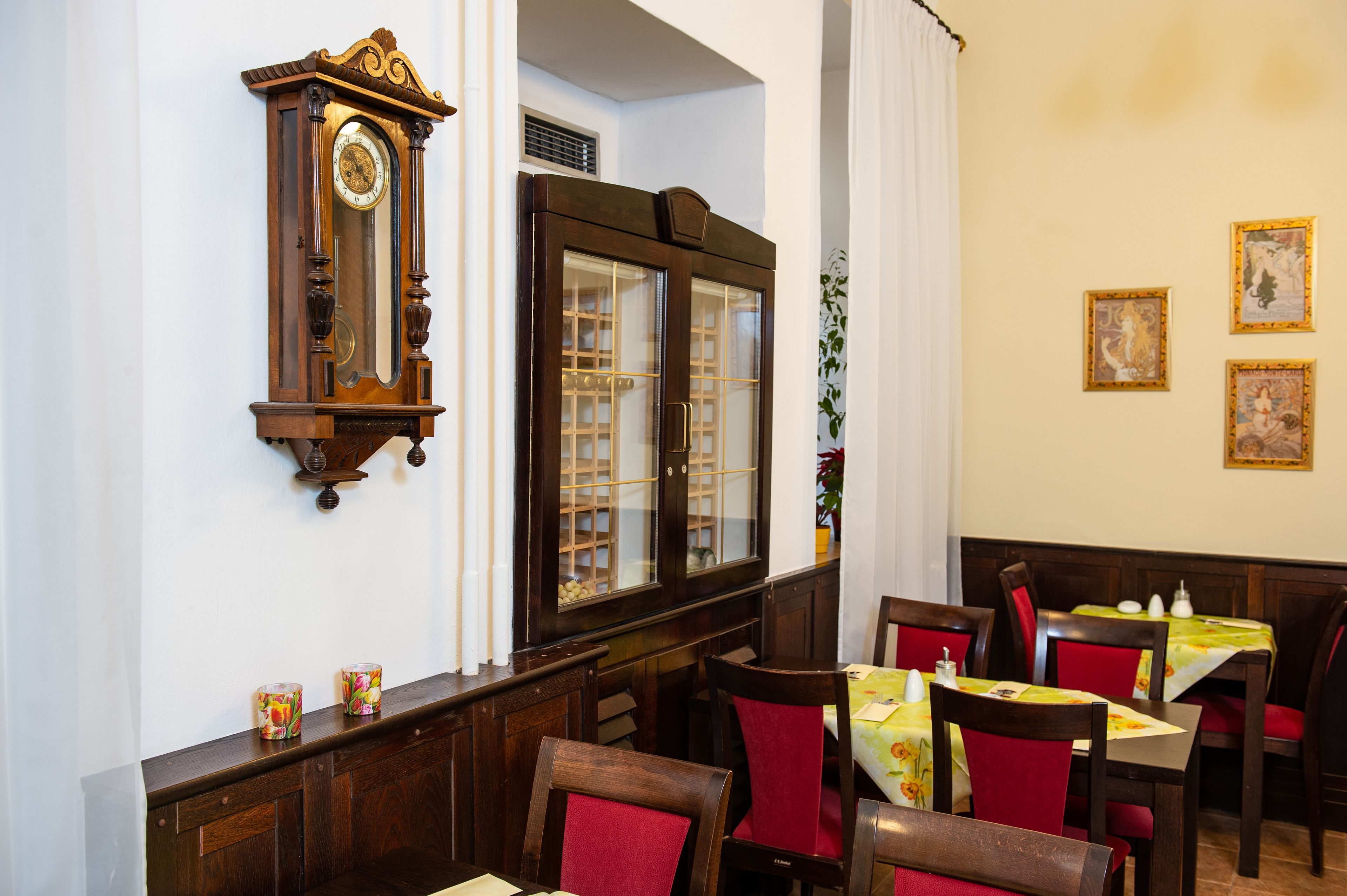 Un'area pranzo con mobili in legno, una sveglia a muro e quadri incorniciati.