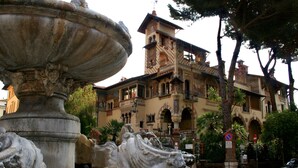 Un edificio histórico con arquitectura ornamentada, una fuente y un cartel de no estacionamiento.