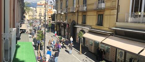 A bustling street with buildings, shops, and pedestrians.