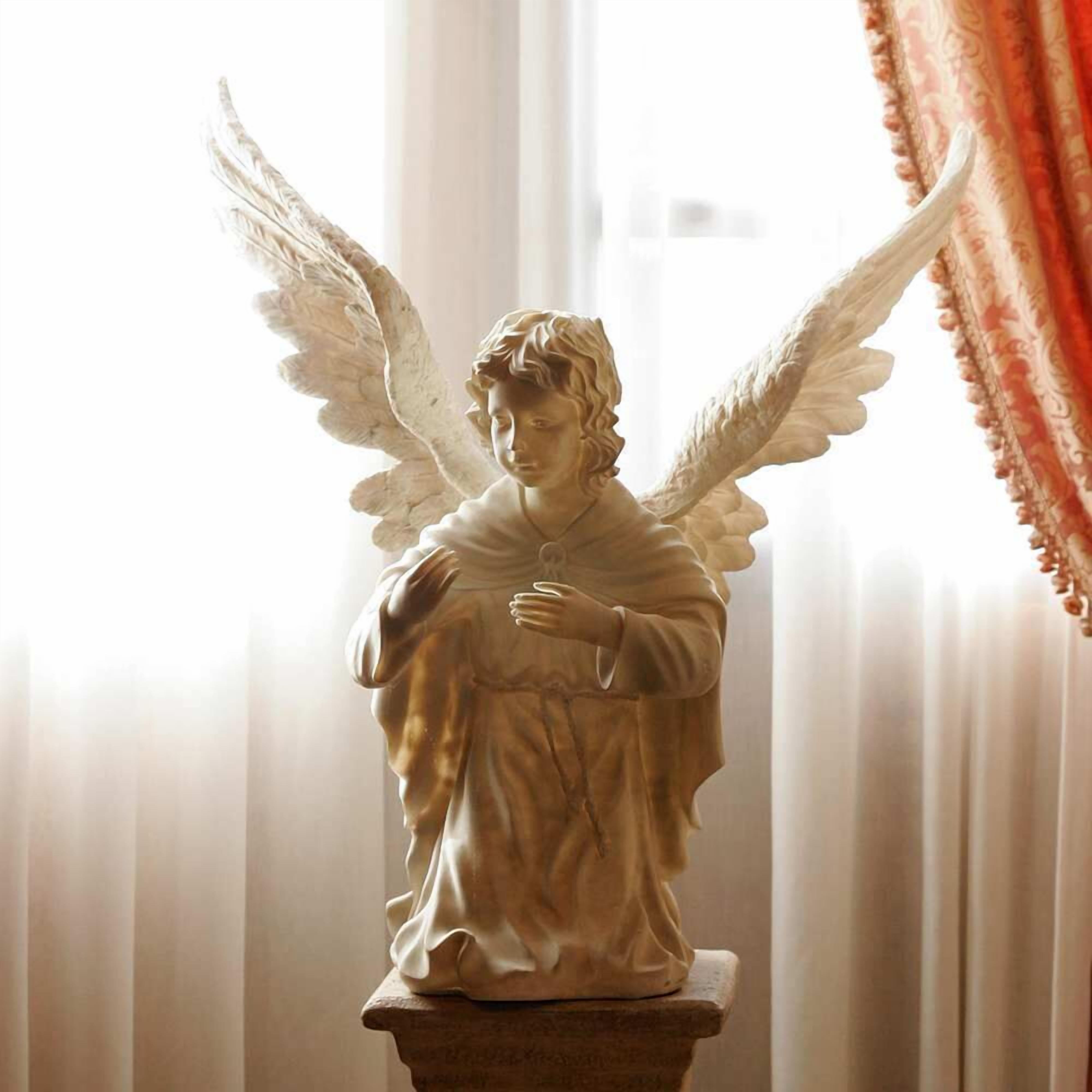 Eine Statue eines Engels mit Flügeln auf einem Sockel.