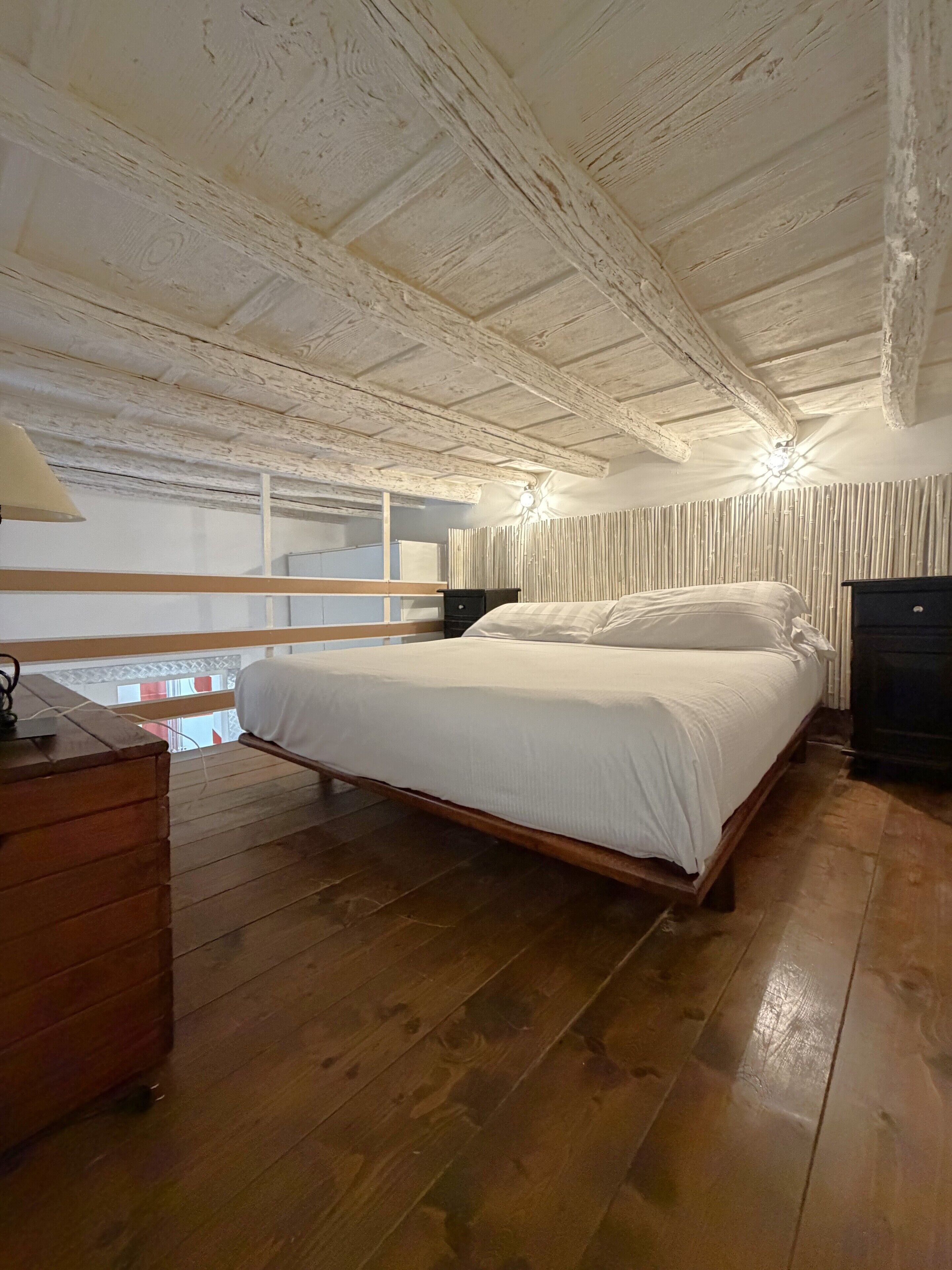 Un dormitorio con cama de madera, cómoda y mesita de noche.