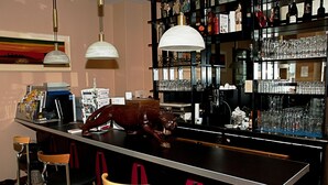 A bar area with a counter, stools, and a decorative animal figure. - Pension ABC (Berlin)