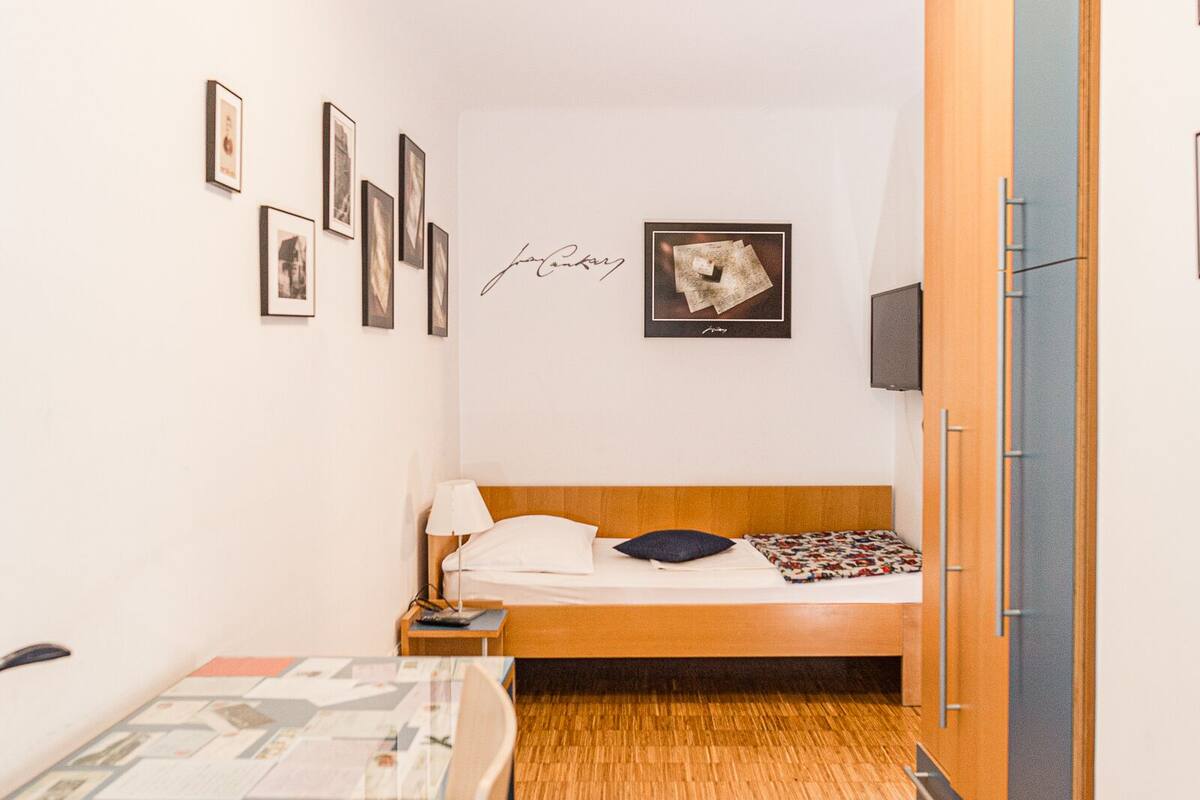 Una camera da letto compatta con un letto di legno, un tavolino e un armadio.