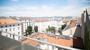 Un paisaje urbano con varios edificios, incluyendo un edificio blanco destacado con tejado de tejas rojas.