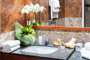 A bathroom with a granite countertop, a sink, a mirror, and a towel rack. - Prince Galles (Rome)