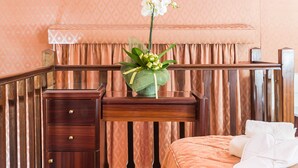 Una habitación de hotel con cama, mesita de noche, escritorio y lámpara.