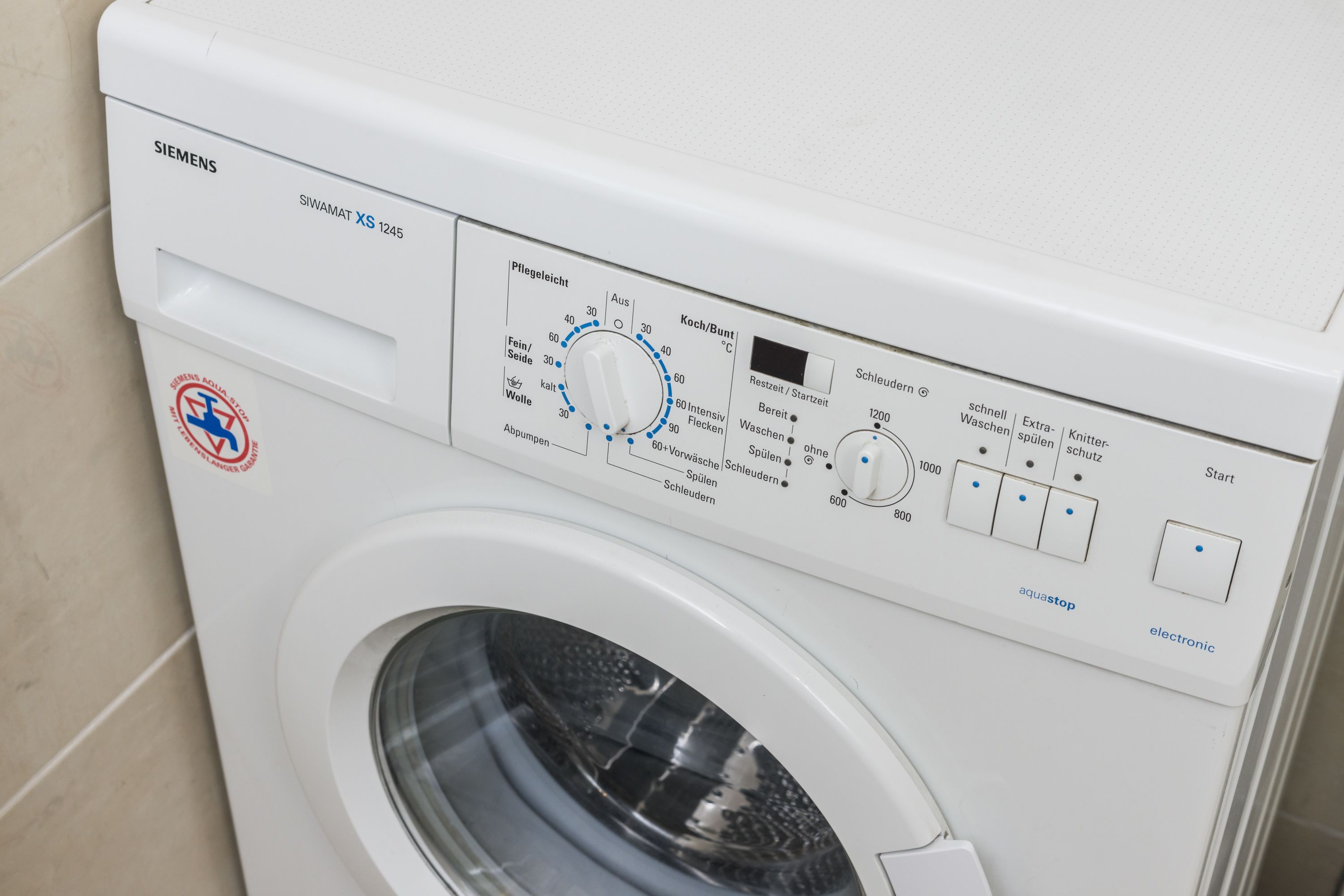 Siemens SIWAMAT XS 1245 -pesukoneen etupuoli, jossa näkyvät ohjauspaneeli, veden tuloliitäntä ja luukku.