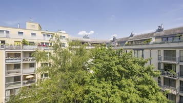 Un edificio residenziale a più piani con balconi, ampie finestre e un albero sullo sfondo.
