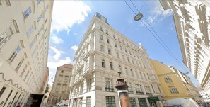 Un edificio histórico con arquitectura clásica, que presenta numerosas ventanas y una entrada destacada.