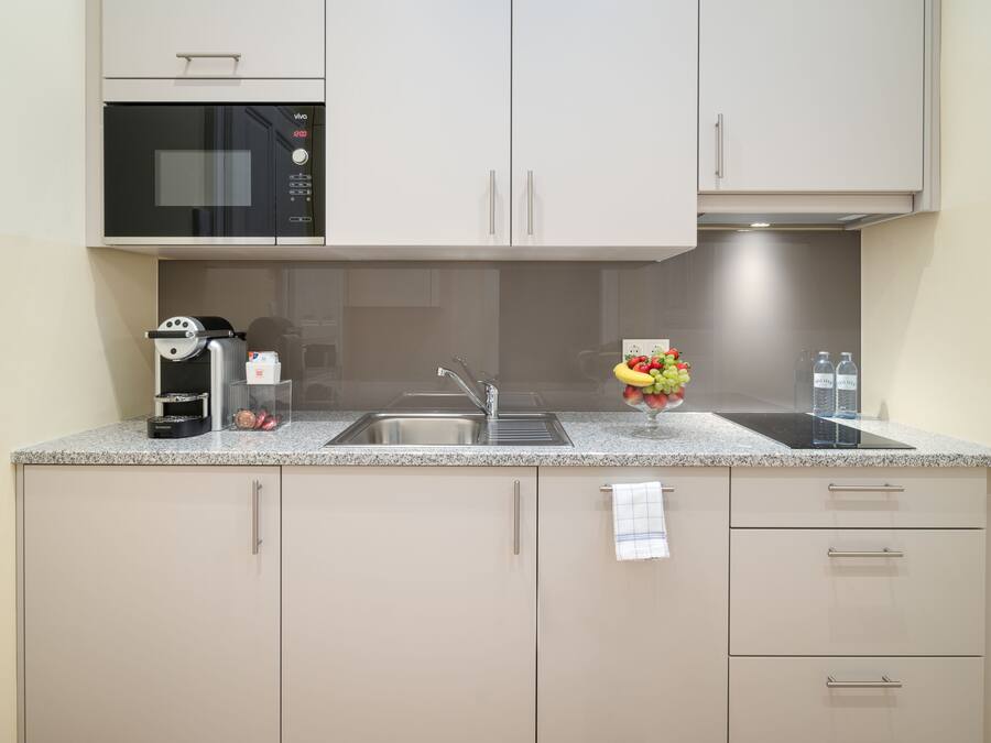 A modern kitchen with a microwave, sink, and cabinets.