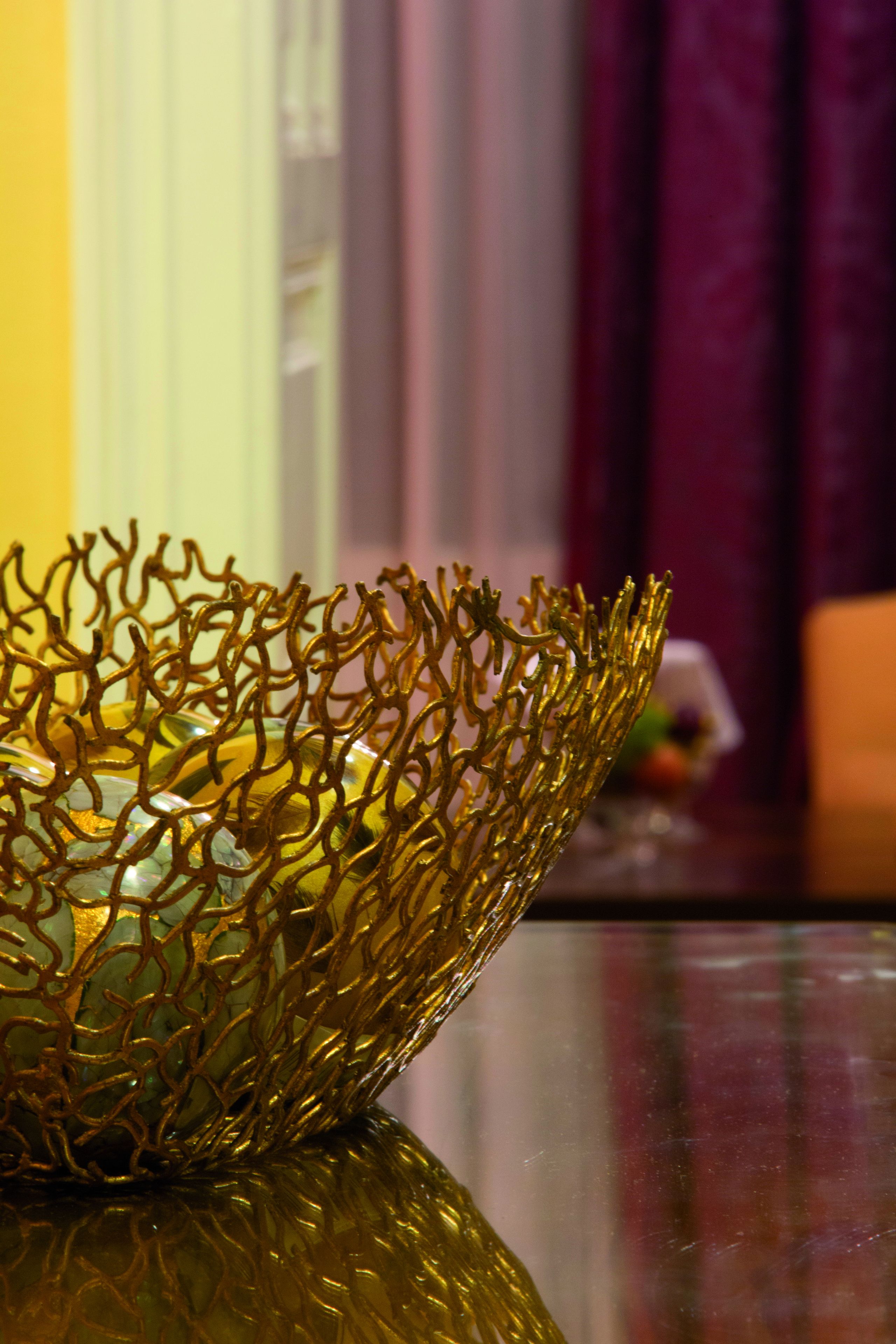 Un cestino dorato decorativo su una superficie riflettente.