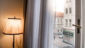 A room with a lamp and a view of a street outside. - Hotel Pension Dormium (Vienna)