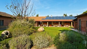 Un edificio con techo solar, un porche cubierto y un césped bien cuidado.