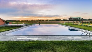 Una piscina con una vista despejada del cielo y árboles lejanos.