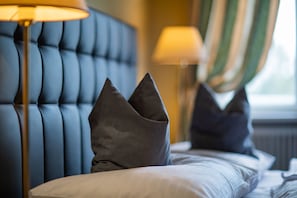 A neatly made bed with a tufted headboard and two bedside lamps. - Hotel Bergwirt Schönbrunn (Vienna)