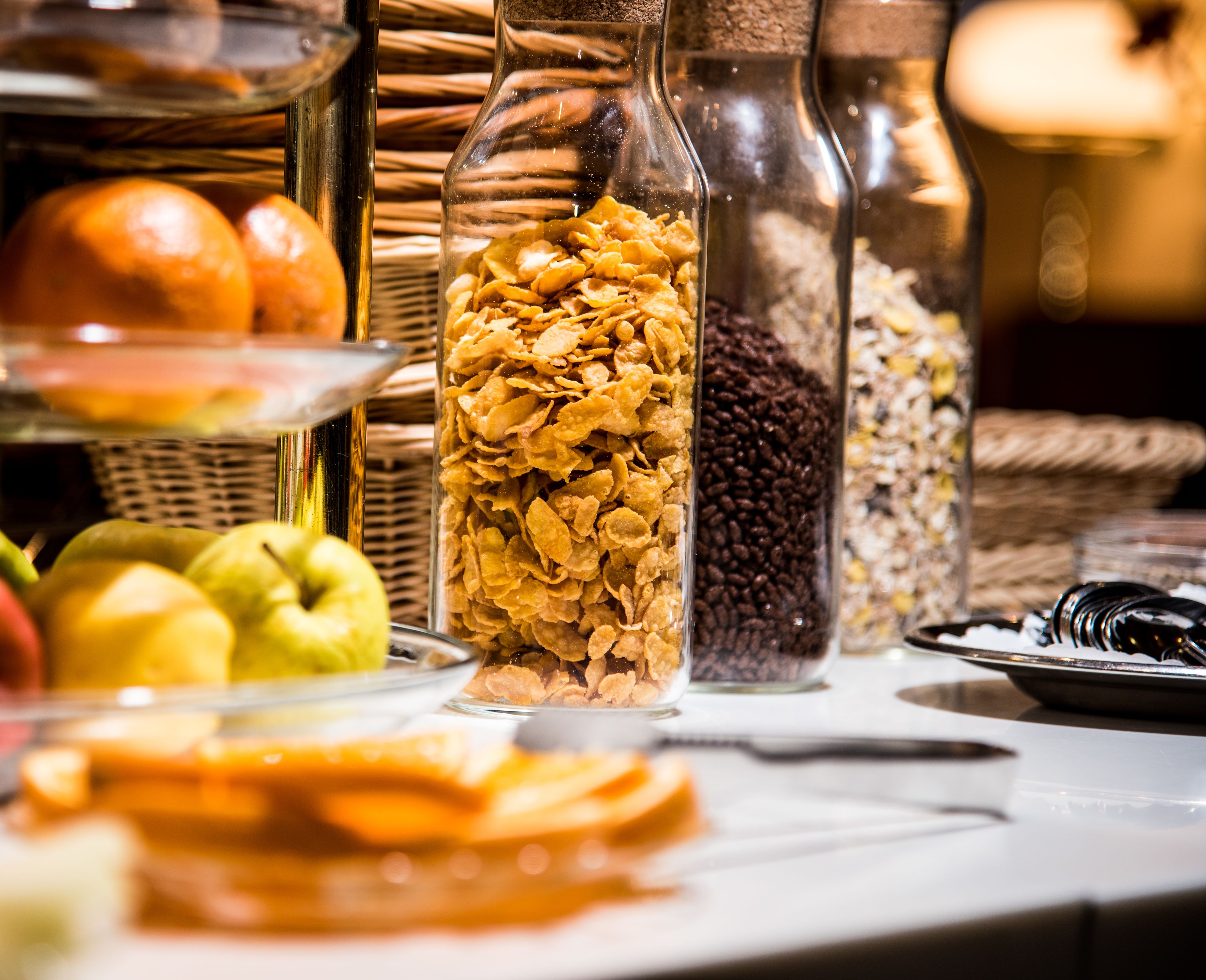 Een buffet met diverse soorten eten, zoals fruit, ontbijtgranen en noten.