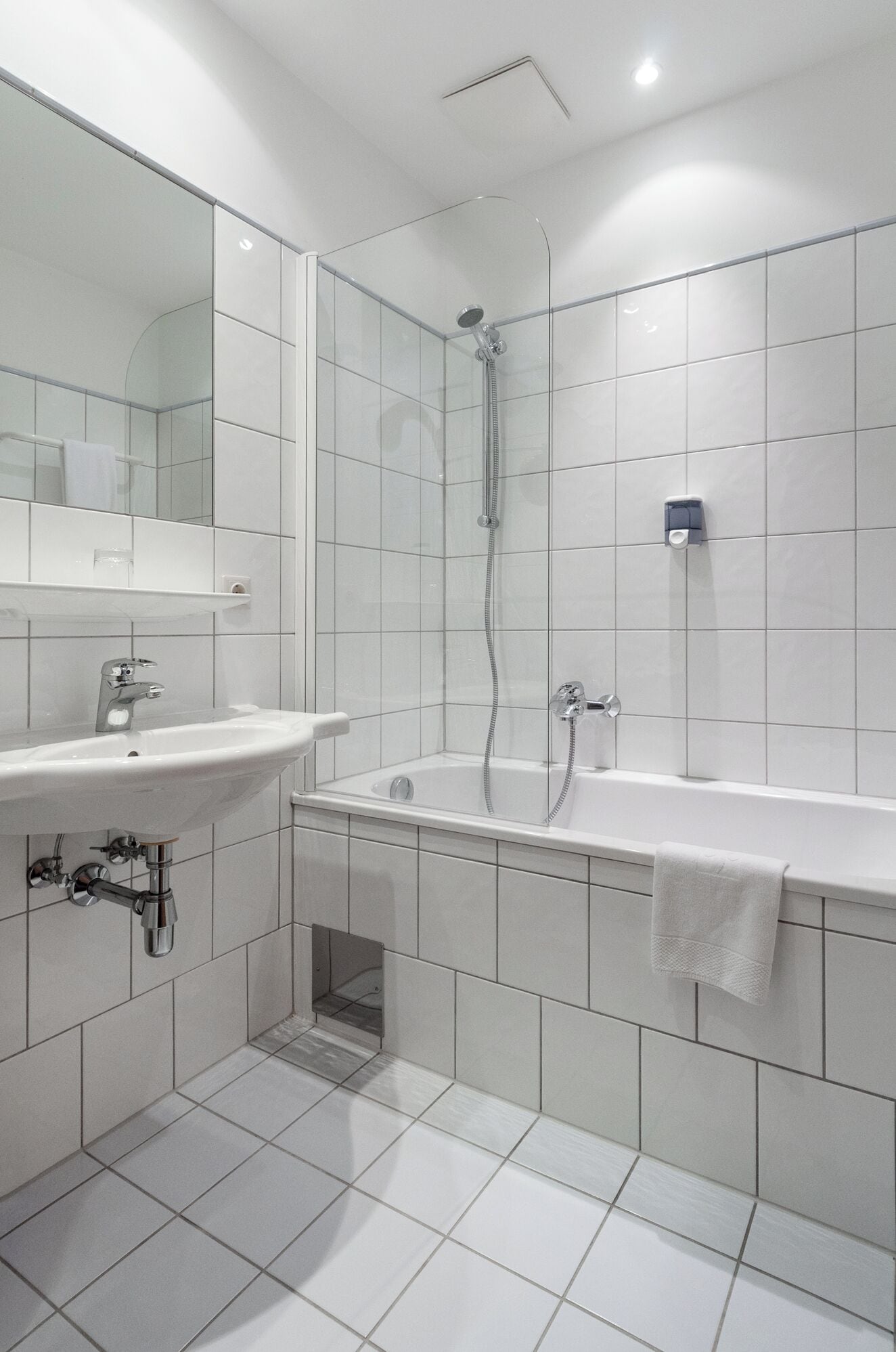A modern bathroom with a sink, mirror, and shower.