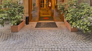A hotel entrance with the name "HOTEL AUSTRIA" and multiple national flags displayed above. - Hotel Austria (Vienna)