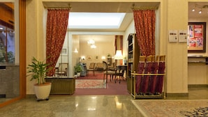 A hotel lobby with a reception desk, seating area, and a chandelier. - Hotel Austria (Vienna)