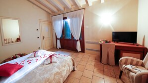 A hotel room with a bed, a desk with a computer, a TV, and a chair. - Relais Villa Selvatico (Roncade)