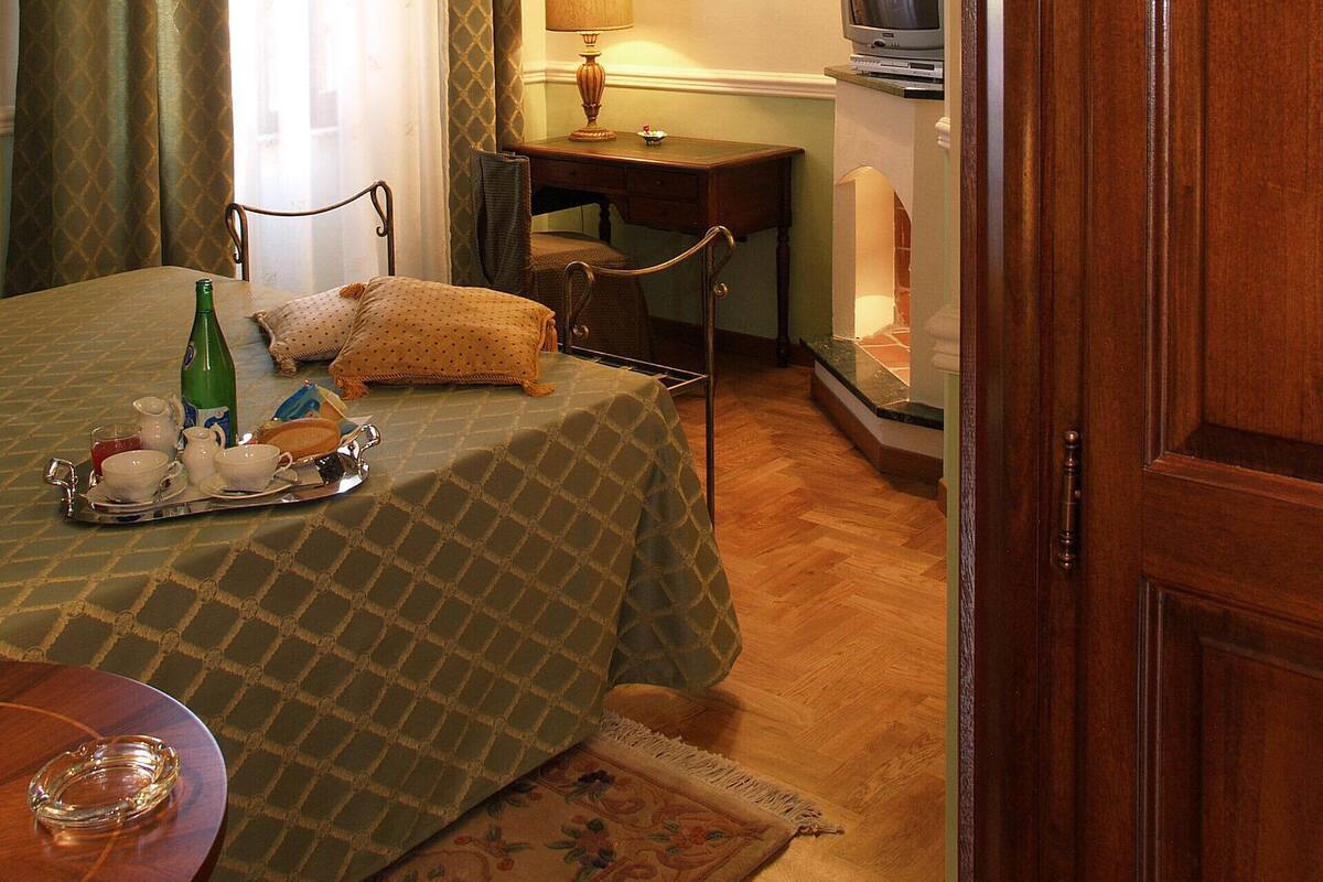 A hotel room with a bed, a desk, a television, and a mirror.
