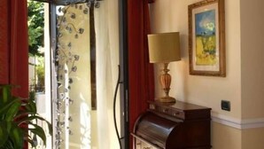 A room with a piano, a painting on the wall, and a large window with curtains. - Petit Château (Montecatini Terme)