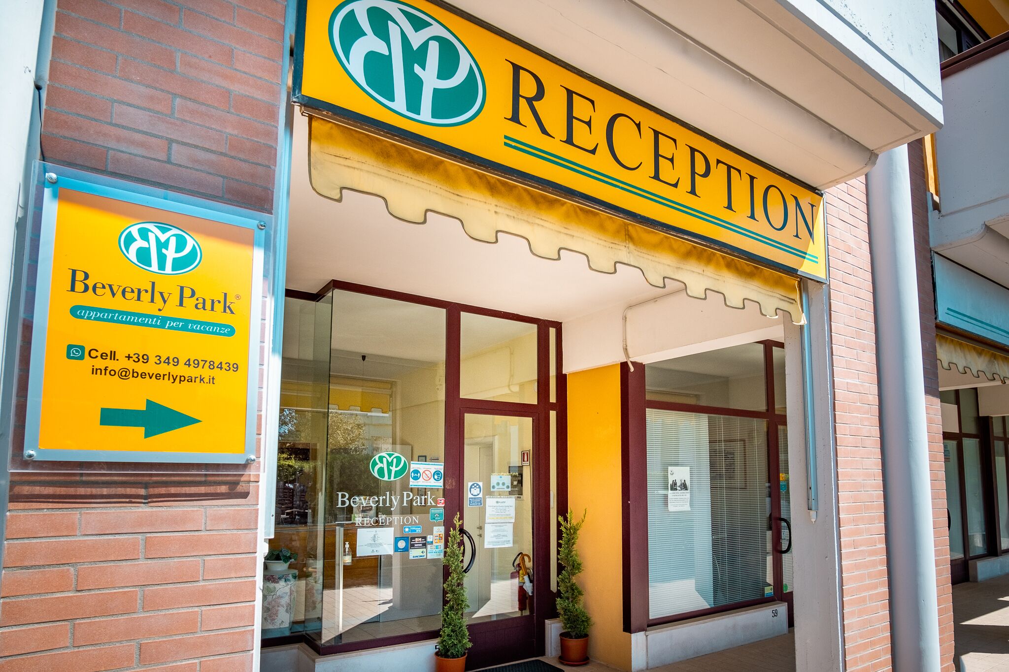 Zona de recepción con un cartel de Beverly Park, que incluye un número de teléfono y una dirección de correo electrónico.
