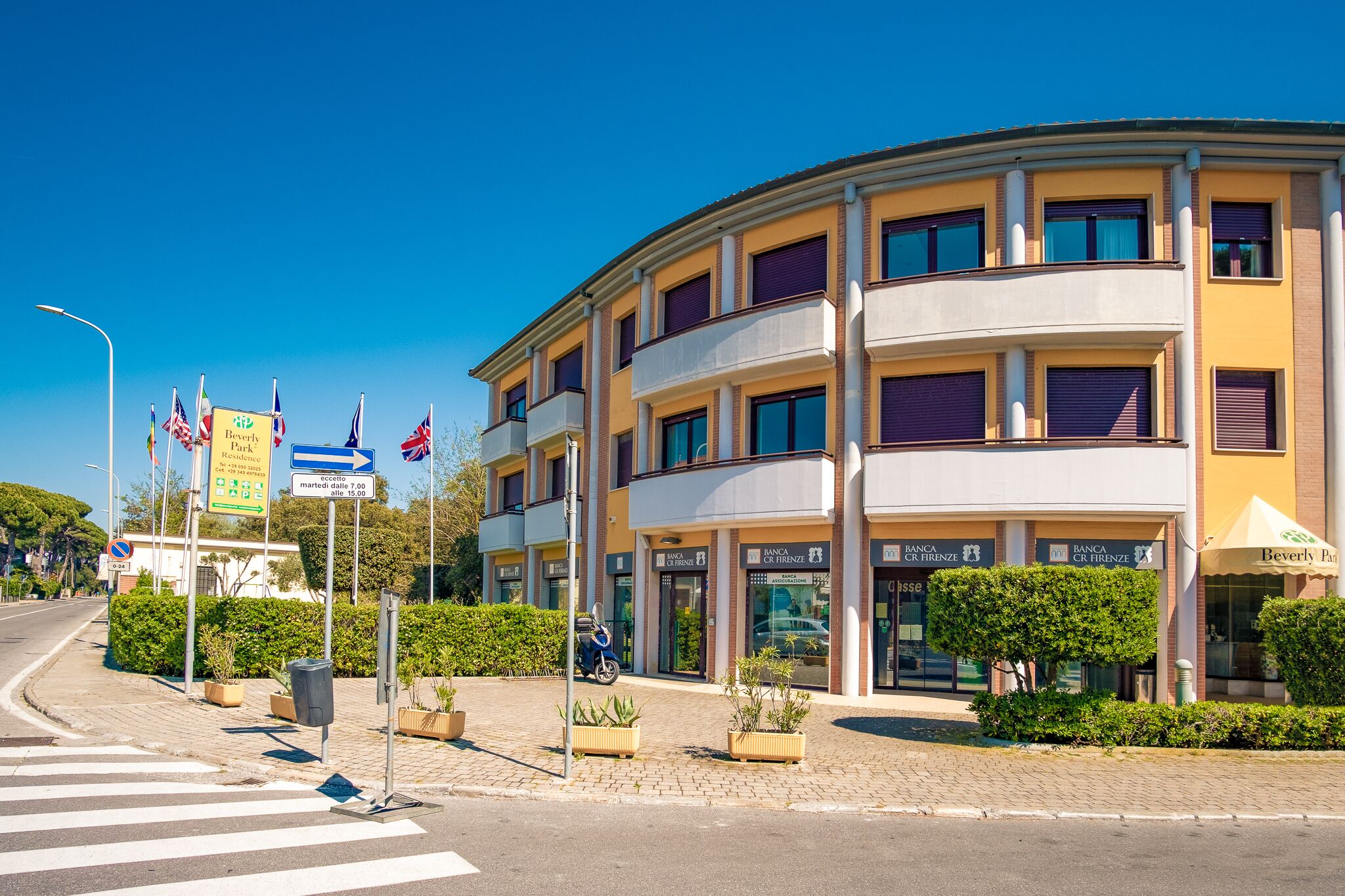 Un hôtel à plusieurs étages, doté d’une façade incurvée, de nombreux balcons et surplombant un ciel d’un bleu éclatant.