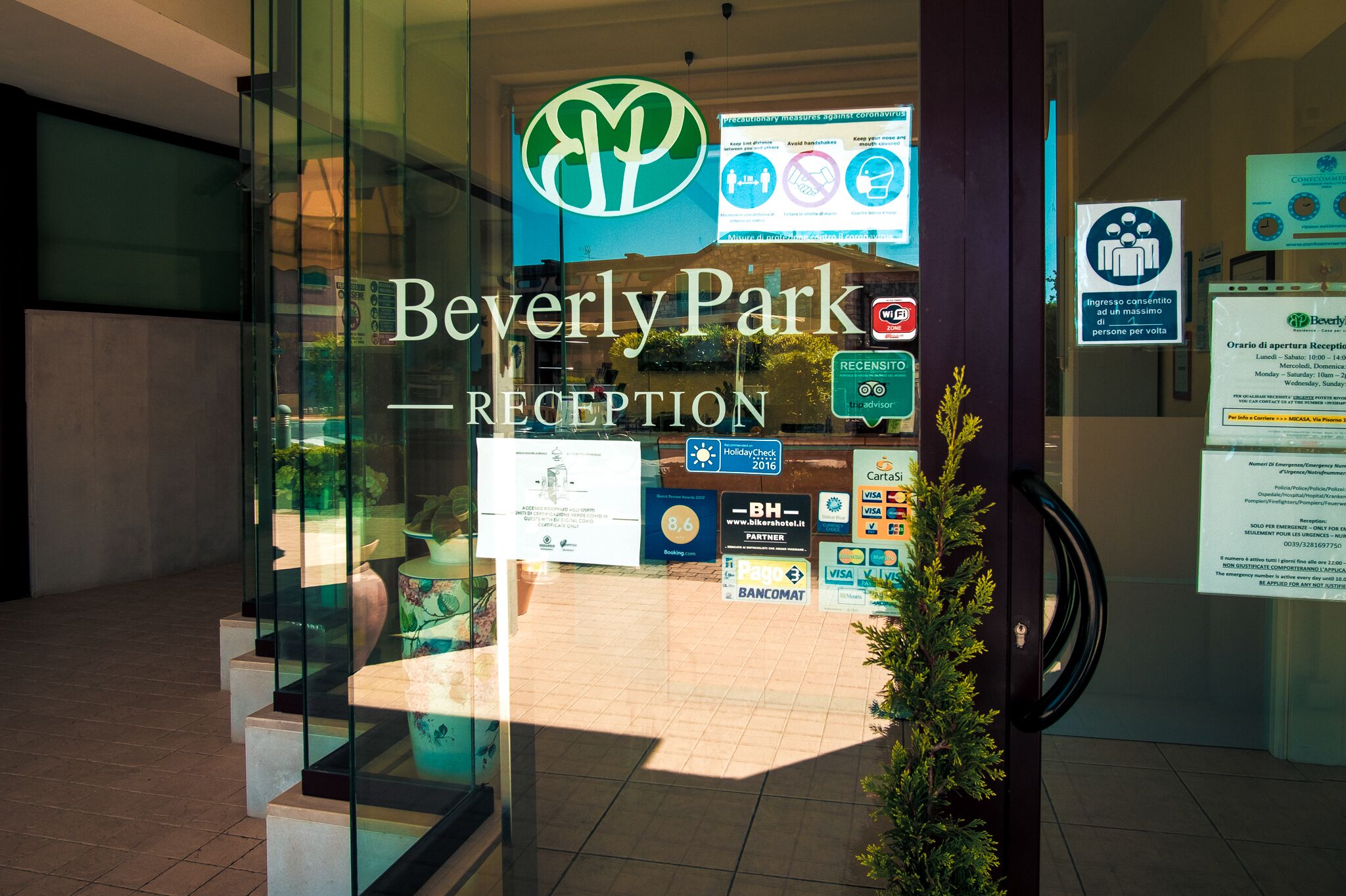 The Beverly Park Reception area with a glass entrance, various informational signs, and a logo.