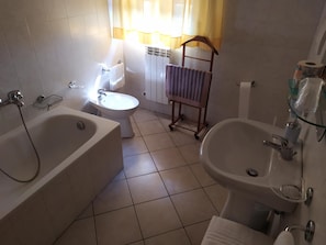 A bathroom with a bathtub, a sink, and a toilet. - Shine (Acqualagna)