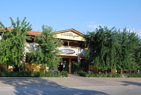 A building with a sign reading "Shine Pizzeria" and "Allergos" above it.