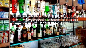 A bar with a variety of liquor bottles and glasses. - Shine (Acqualagna)