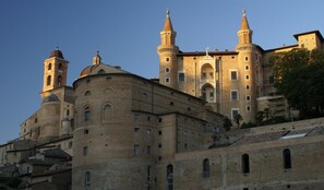 A historic building with a prominent bell tower and a central tower with a dome.