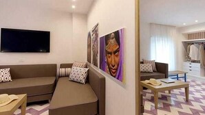 Un salon moderne avec un canapé, une table basse et un téléviseur à écran plat fixé au mur.