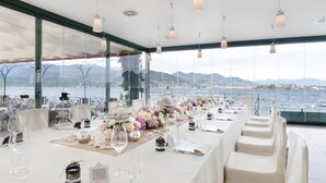 A long dining table set for a wedding with white tablecloths, clear glassware, and floral centerpieces. - Hotel Belvedere (Stresa)