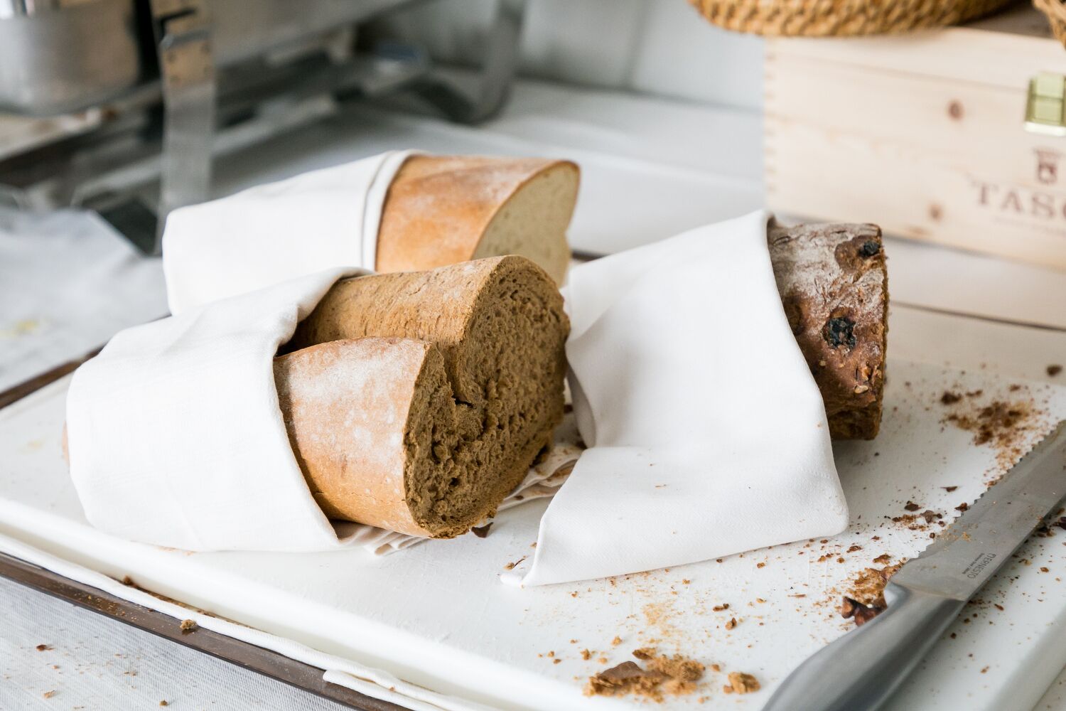 Una pagnotta di pane su un tagliere bianco con un coltello.