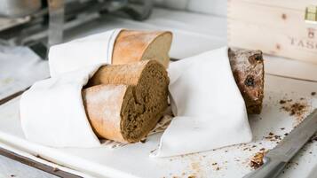 Een brood op een wit snijplank met een mes.