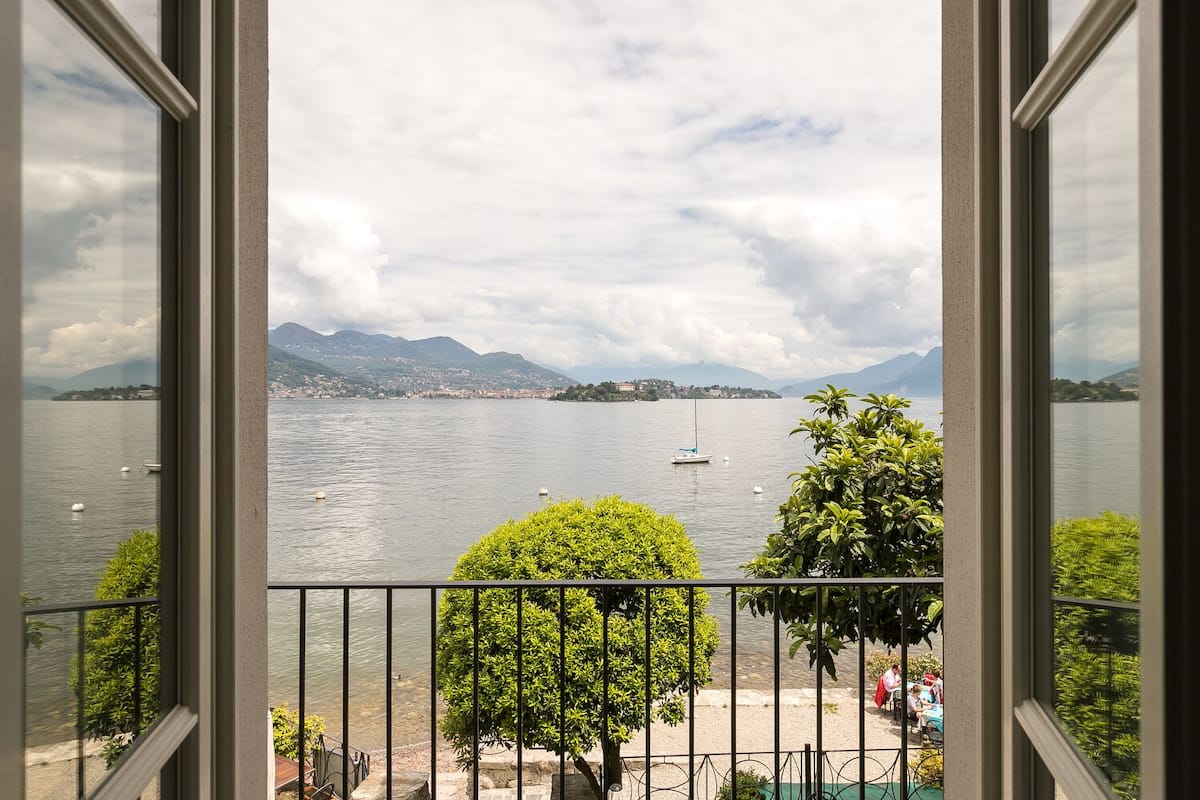 A view of a lake with boats, mountains, and a distant town.