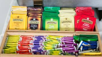 Una caja de madera con varias bolsitas y paquetes de té Twinings.