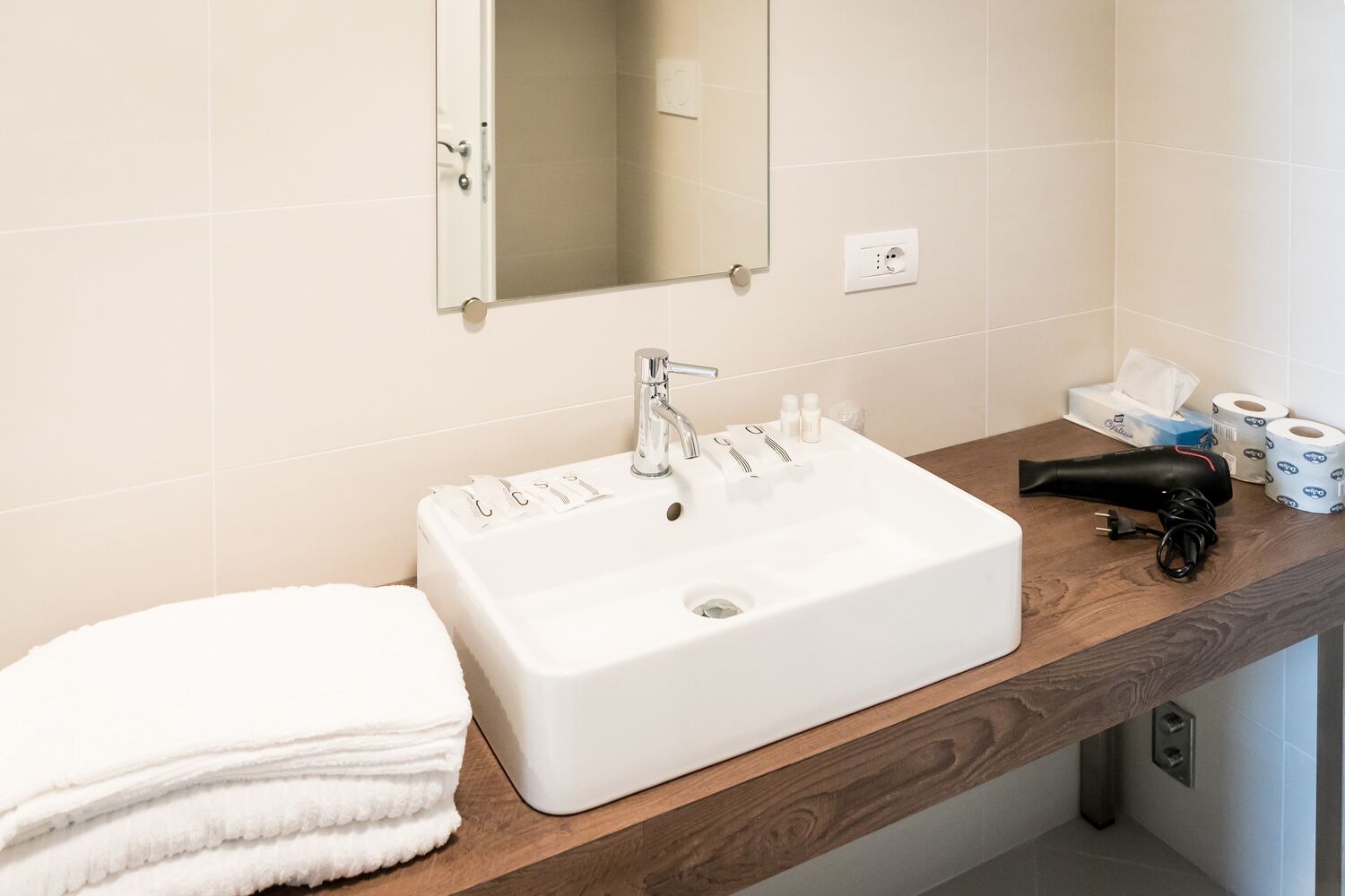 Une salle de bain avec un lavabo blanc, un miroir et un porte-serviettes.