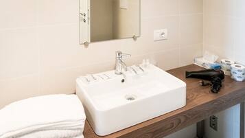 Une salle de bain avec un lavabo blanc, un miroir et un porte-serviettes.