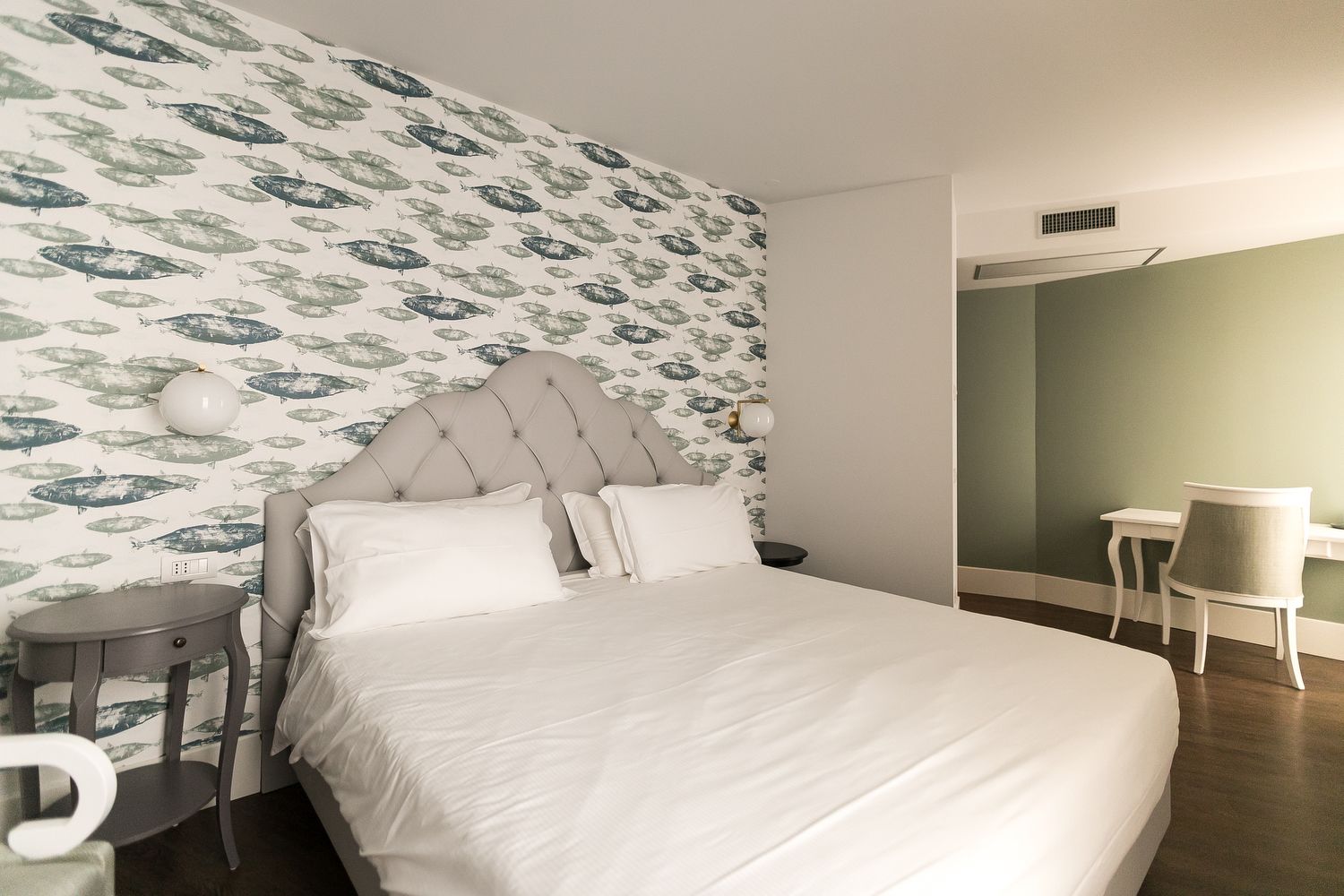 A neatly arranged bedroom with a bed, bedside tables, and a chair.