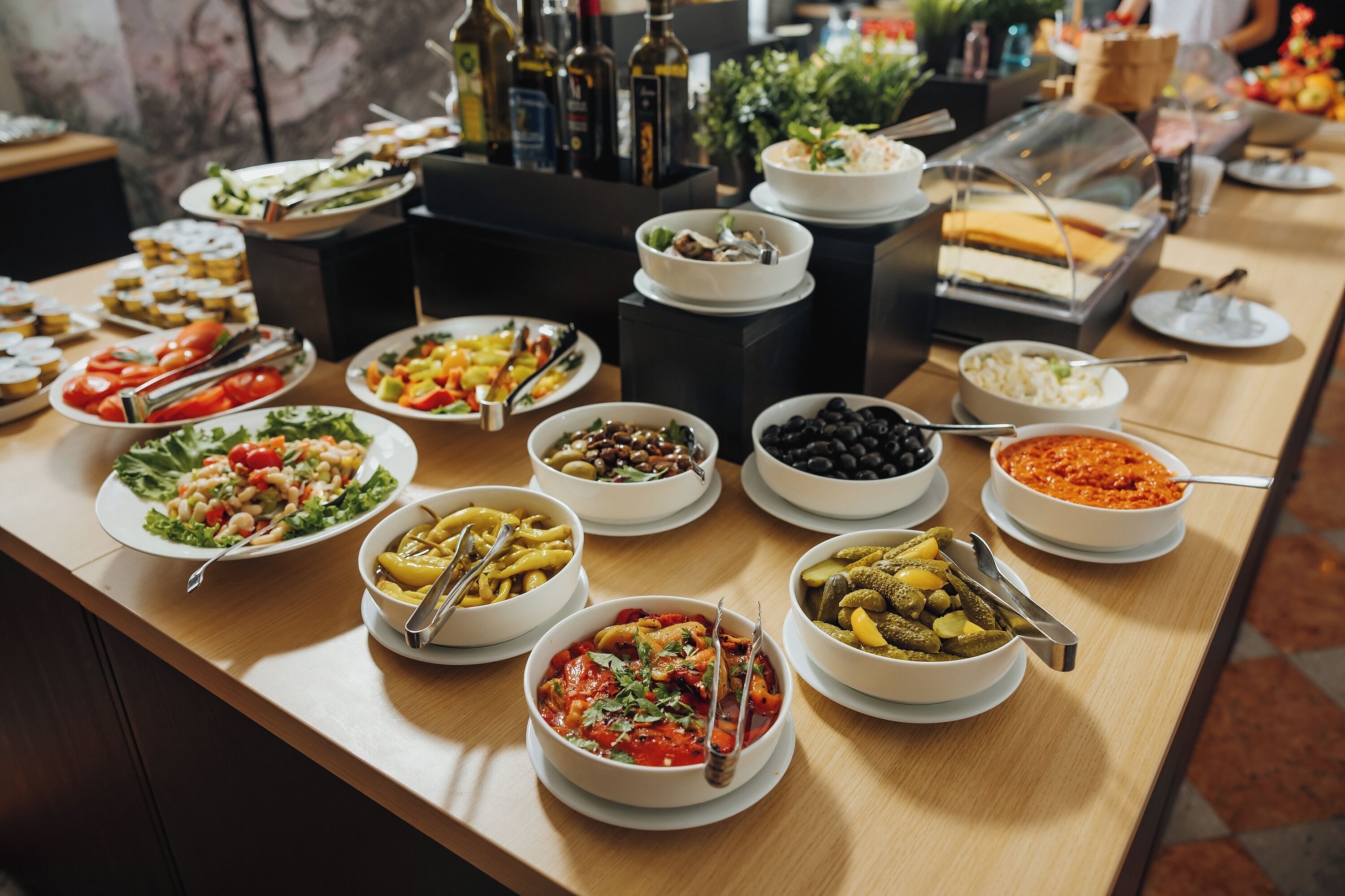 A buffet table with various dishes and condiments.