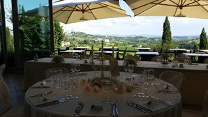 A table set for a meal with a view of a vineyard and distant hills. - Villa Ducci (San Gimignano)